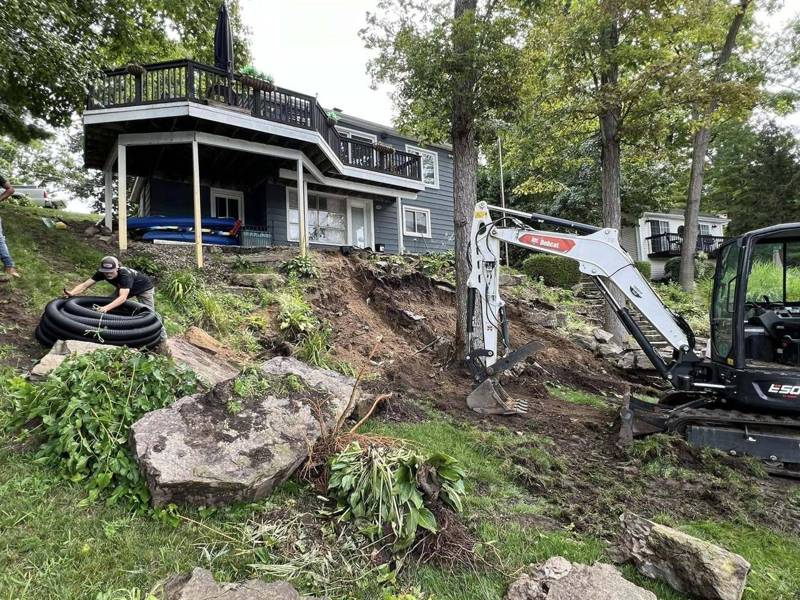 Mini excavator clearing and working a steep slope