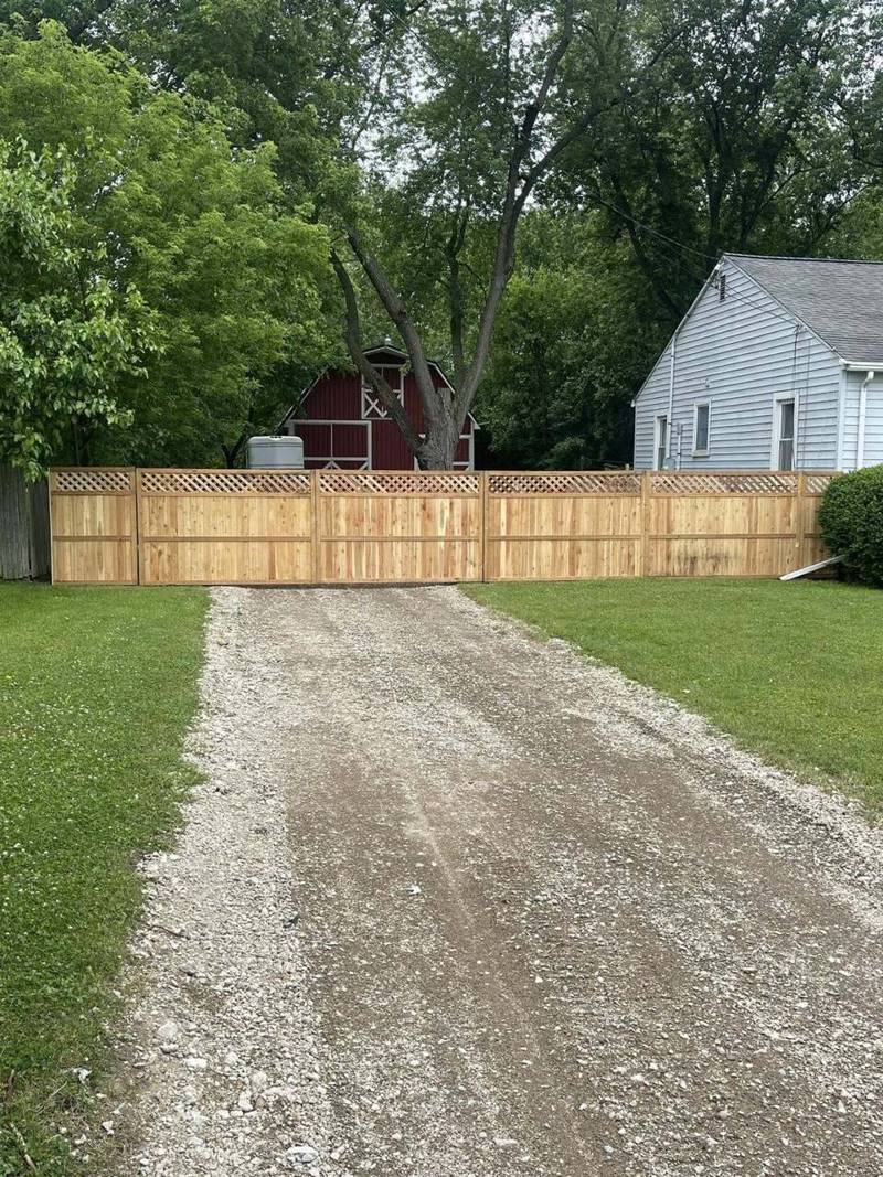 Gravel driveway leading to a fence line